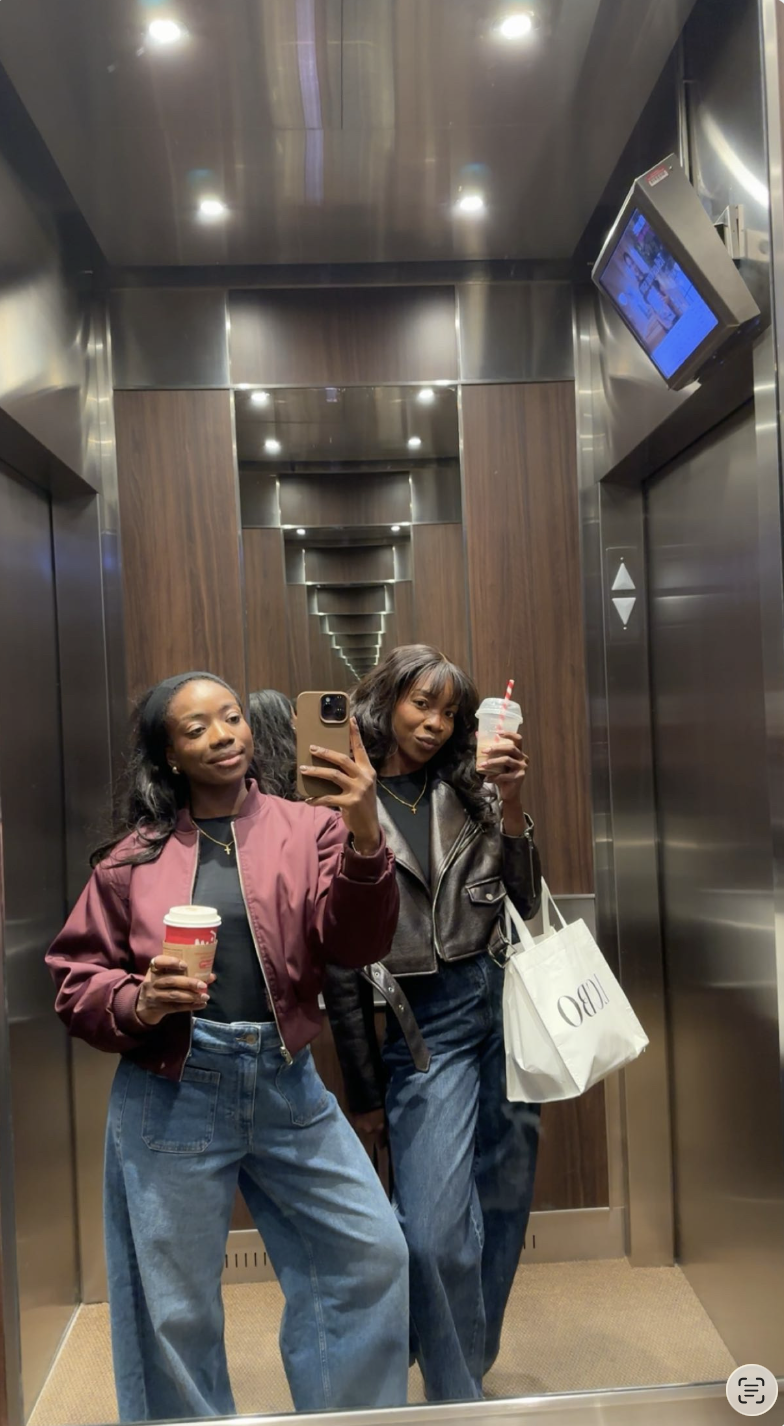 Tumininu and Adefisola taking a mirror selfie together in an elevator, holding drinks and shopping bags.